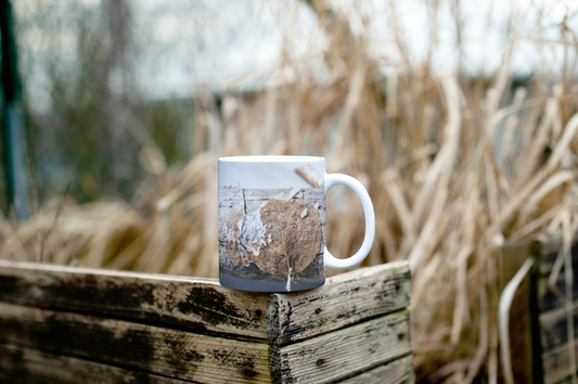 White ceramic mug with macro photo of dried leaf and bark on rustic wood outdoors
