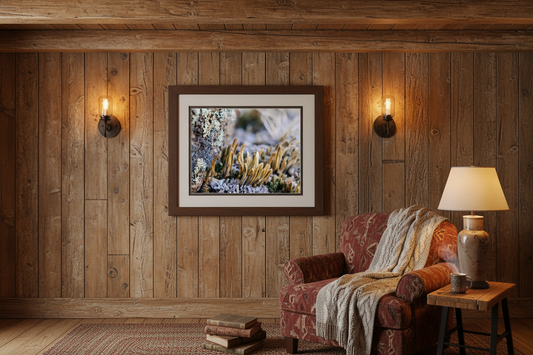 Cozy rustic living room with macro lichen photography wall art, wood walls, armchair and lamp.